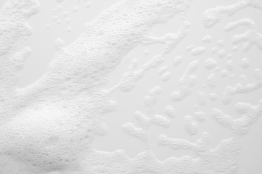 A close up of a white bathtub with soap bubbles photo