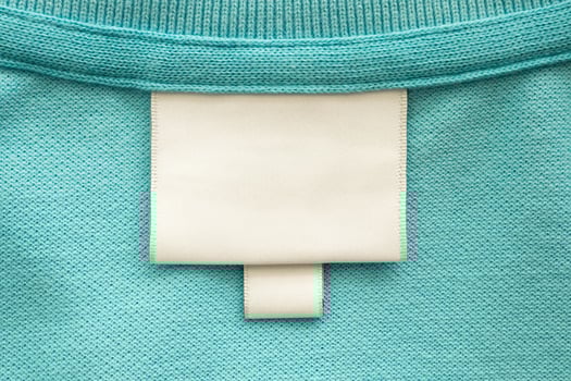 A close up of a white label on a turquoise shirt photo