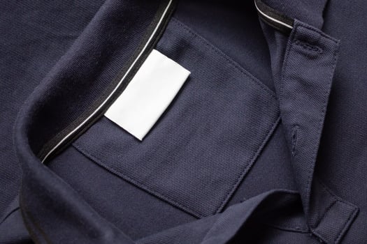 A close up of a dark blue jacket with a white label photo