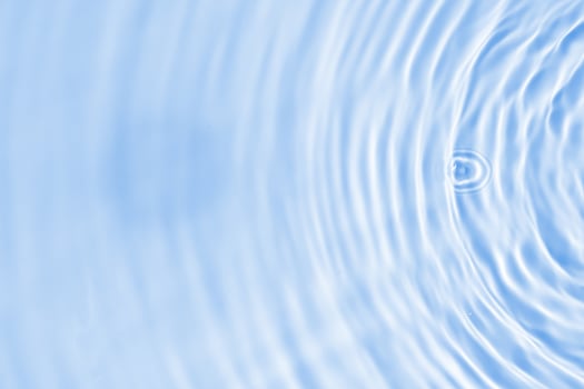 A circular pattern of water ripples on a blue background photo