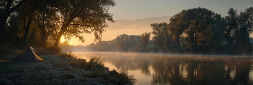 Tranquil Sunrise Along a Serene Riverbank with a Tent Surrounded by Lush Trees and Misty Atmosphere photo