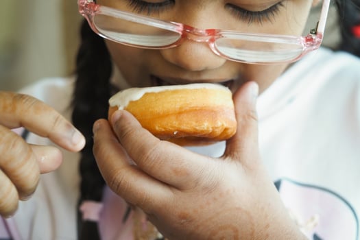 Child enjoying a sweet treat in a cozy indoor setting photo