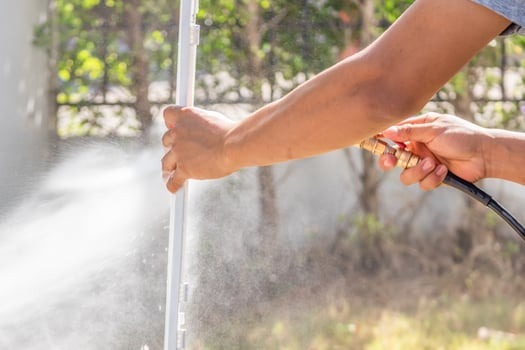 A person is spraying water on a pole photo