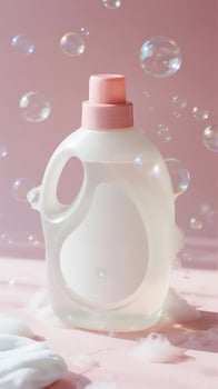 A bottle of liquid and soap bubbles on a pink surface photo