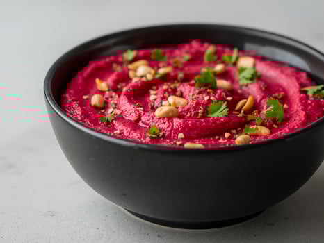 A bowl of beetroot dip with nuts and herbs photo