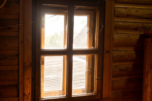 A wooden window in a wall made of logs with white background. photo