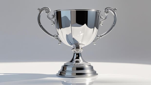 A shiny silver trophy on a white surface indoors photo