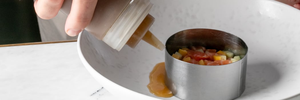 Squeezing a tangy elixir onto diced nectar in a culinary ring, gastronomic artistry, coinciding with National Chefs Day photo