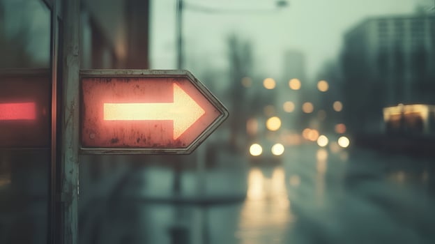 Glowing directional sign in a rainy city with blurred urban backdrop and moody atmosphere photo