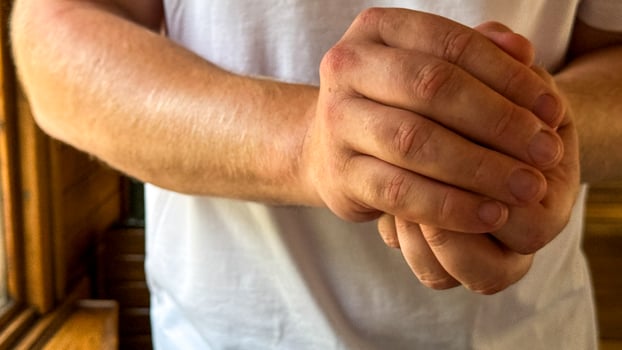 A Caucasian mans hands, clasped resolutely, symbolize unity and contemplation during the tranquil Scandinavian Midsummer festival photo