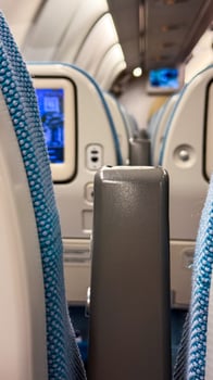 Airplane seatback screens illuminate the cabin, echoing wanderlust whispers, Armrest Day comfort, Aeroponic Gardens Festival tranquility photo
