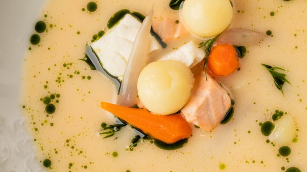 Creamy Nordic fish soup artistry waltzes with dill dressed carrot crescents, invoking Hygge coziness and Kraftskiva festivity flavors photo