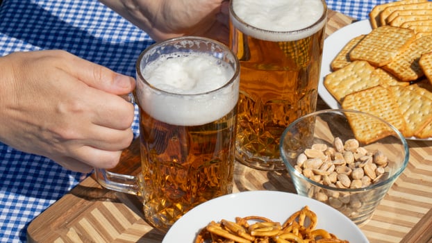 Cozy Oktoberfest picnic with frothy beer, crunchy pretzels, and rustic crackers, celebrating camaraderie, Bavarian delights under sunny skies photo