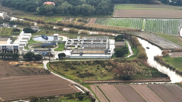 Aerial view of futuristic water treatment plant amid serene farmland, embodying Earth Days sustainable innovation and community resilience photo