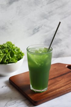 Green vegetable juice glass with fresh veggie. Healthy drinking photo
