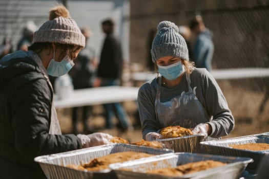 Two people wearing face masks and gloves serving food photo