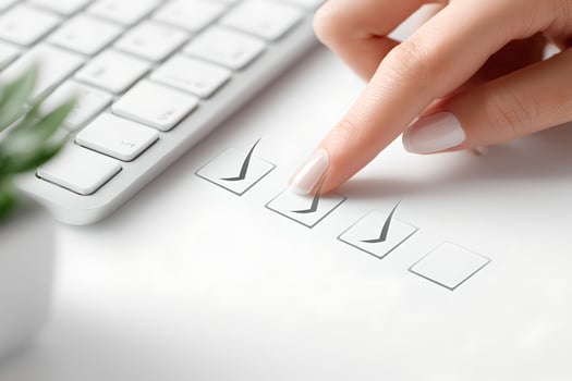 A person's hand is touching a check box on a white desk photo