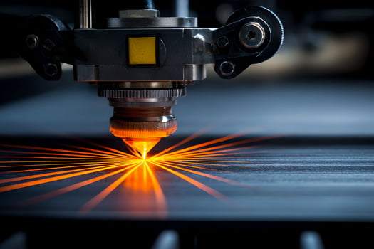 A laser cutting machine is shown with orange light photo