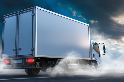 A white truck driving on a road with smoke coming out of it photo