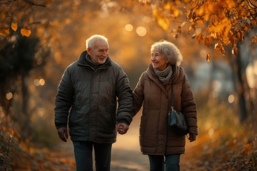 An older couple walking in the autumn leaves photo