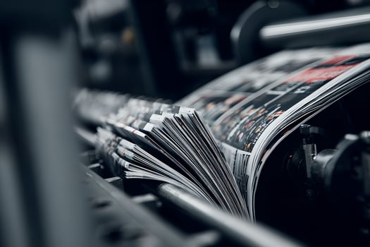 A newspaper is being printed on a machine photo