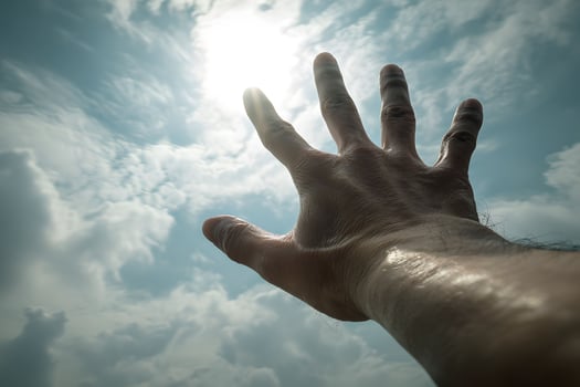 A hand reaching up to the sun photo