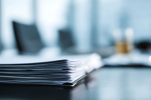 A stack of papers on a table in a meeting room photo