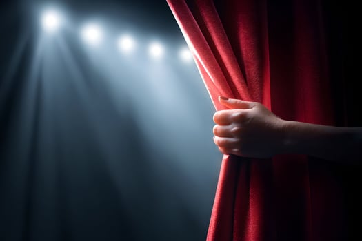 A person's hand is holding a red curtain photo