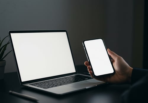 Laptop and Smartphone with Blank Screens for Mockup on Dark Desk photo