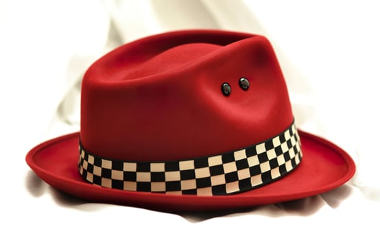 Stylish red fedora hat with checkerboard band and black studs photo