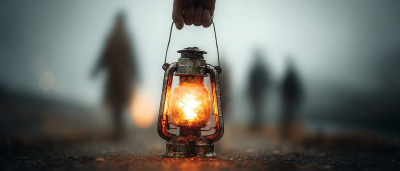 A hand holding a glowing lantern in fog. photo