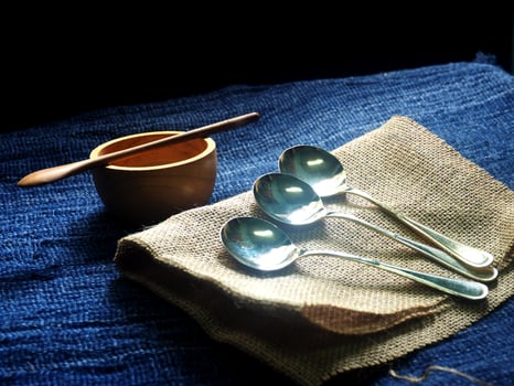 Three spoons and a bowl on a cloth photo