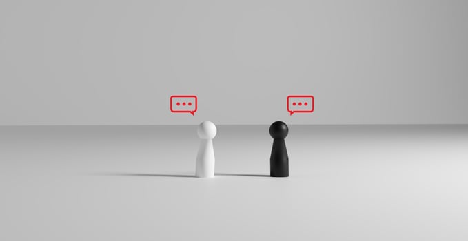 Minimalistic illustration of black dolls and white pawn facing each other with ellipsis speech bubbles, representing silent conversation, disagreement, or communication gap between two parties. photo