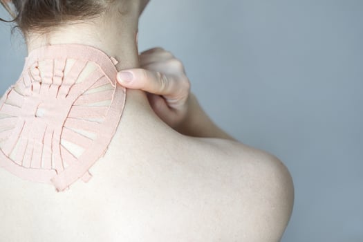Female caucasian adult with therapeutic neck tape for pain relief and muscular support treatment. photo
