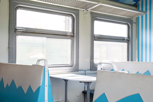 Old empty train interior with blue and white seats and large windows. photo