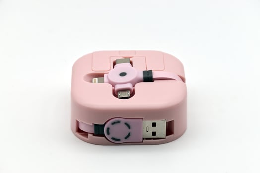 A pink portable multi-charging cable with various connectors designed for mobile devices is presented on a clean white background. photo