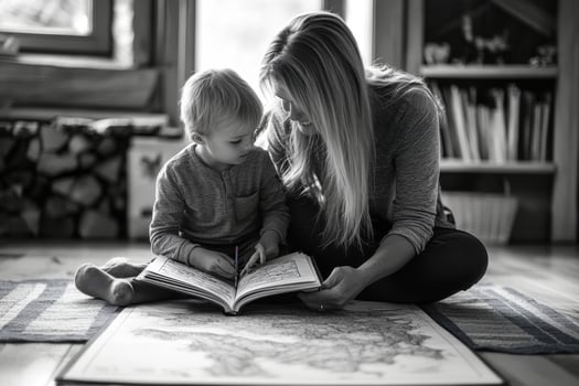 A woman and child reading a book on the floor photo