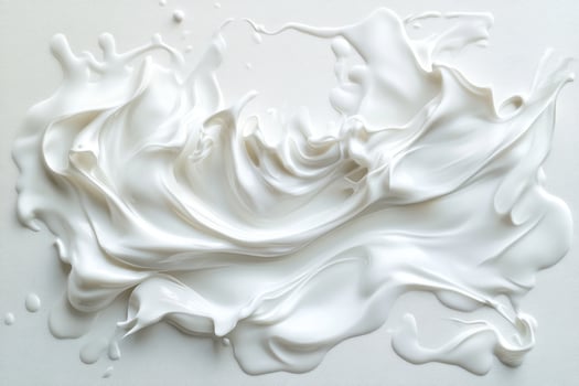 A white liquid is being poured into a bowl photo