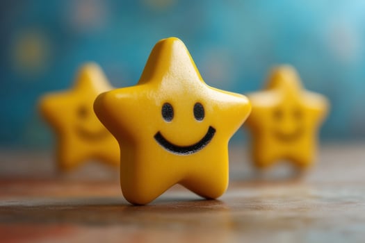 Three yellow star shaped toys with a smiley face photo
