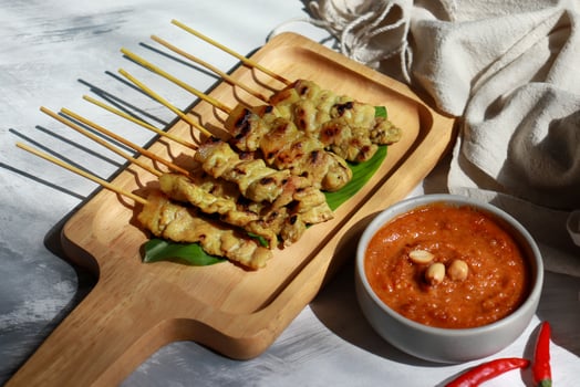 Pork satay grilled skewer with peanut sauce on wooden plate. photo