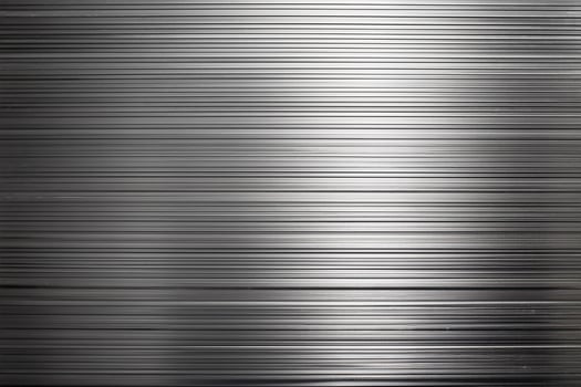 Reflective metal surface with light and shadow on a grooved metallic sheet background . photo