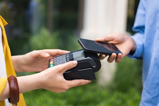 A person using a smartphone to make a contactless payment at a point-of-sale terminal. Modern technology and finance concept. photo