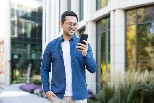 Man with smartphone outside building photo