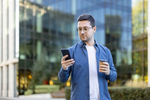 Man with coffee checking his phone photo
