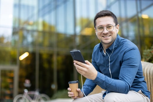 man with phone and coffee outdoors photo