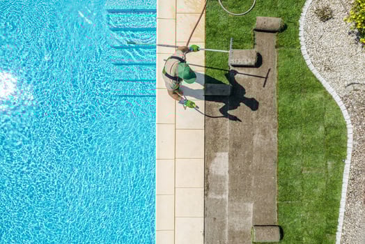 Gardener Installing New Grass Turfs Around Outdoor Swimming Pool photo