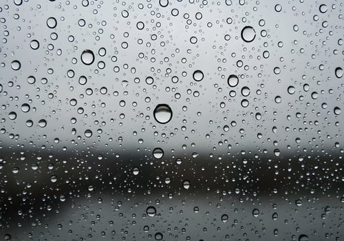 Macro rain droplets on glass window with blurred nature background, clean and sharp abstract texture image with natural lighting and no human elements photo