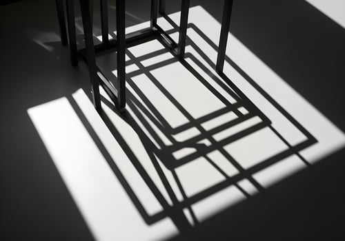 Geometric abstract shadow patterns created by sunlight filtering through objects, sharp natural light photo without any people or logos, perfect for design backgrounds