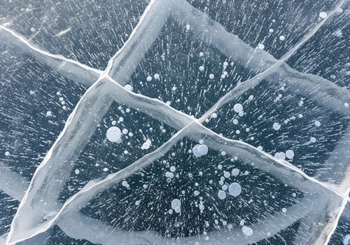Close-up texture of cracked ice surface with detailed air bubbles and crisp natural lighting, abstract cold-themed background image free of noise and human elements photo