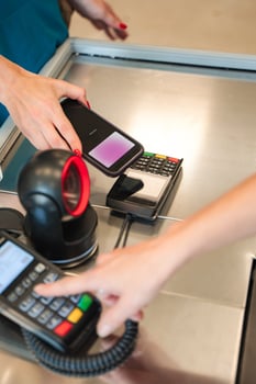 Woman paying with smartphone using NFC technology in supermarket photo